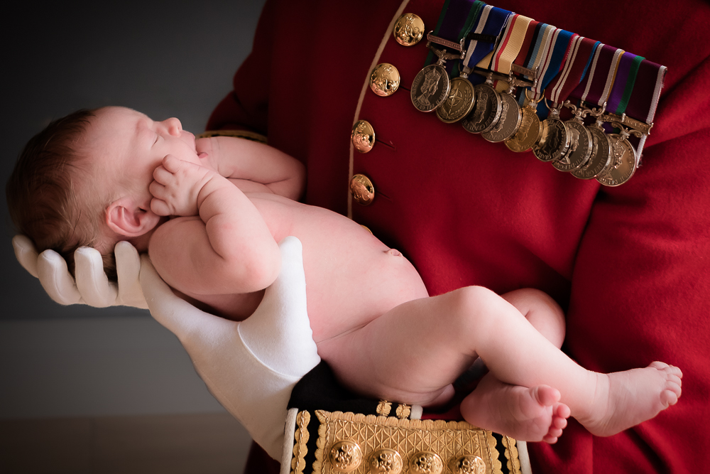 Soldier holding their nude newborn