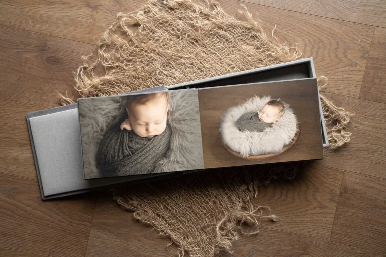 Bespoke photo album laid on wooden floor at photography studio of H Jones Photography, Hampshire.