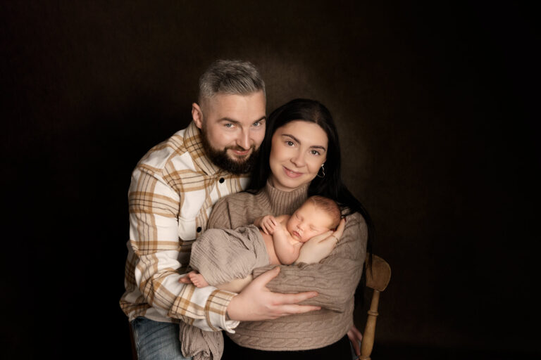 New parents cradling their newborn baby at a photo studio near Andover.