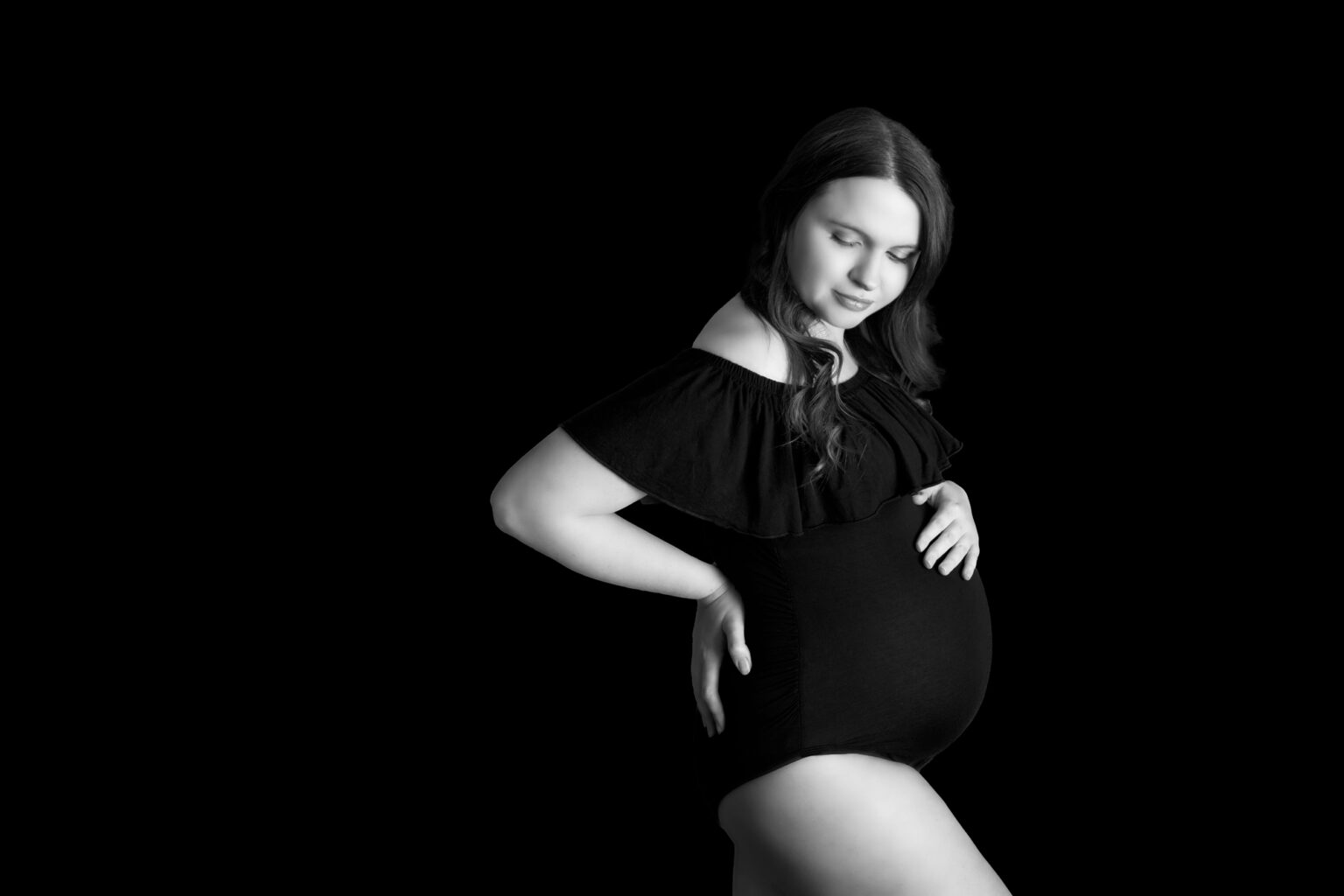 Elegant mum to be posing in black and white image wearing a black maternity bodysuit