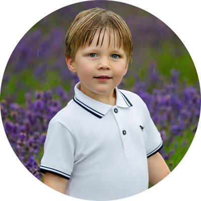 Young boy smiling in the rain at lavender field photoshoot