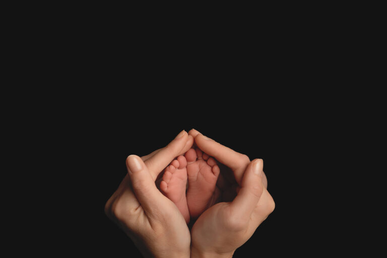 newborn baby feet being held in mum's hands at a photoshoot near Stockbridge in Hampshire.