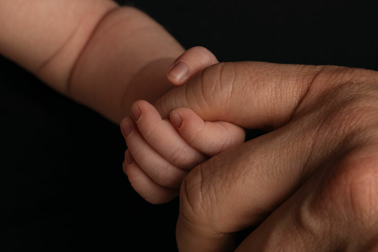 newborn baby's hand holding dad's finger at photoshoot in hampshire