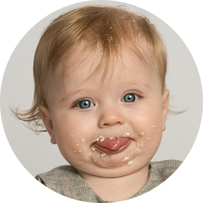 One year old with face covered in cake at first birthday photoshoot.