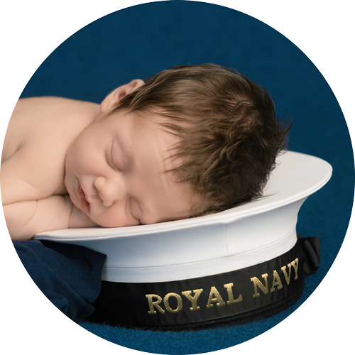 Newborn baby lying on a Royal Navy hat for a review of H Jones Photography Andover