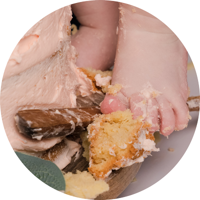 Close up of a baby&rsquo;s feet covered in cake during a cake smash photoshoot in a studio in Andover, Hampshire.