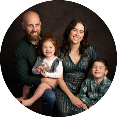 Natural family portrait of parents with two young children smiling together during a studio photoshoot near Andover, Hampshire