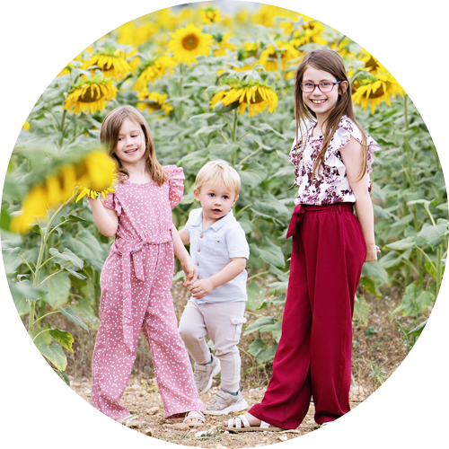 Children walking through sunflowers during a Hampshire family photography session.