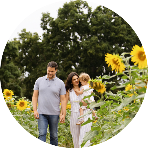 Family walking together in a Hampshire sunflower field.