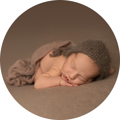 Peacefully sleeping newborn baby wearing a soft knit bonnet during a professional newborn photography session in Hampshire, photographed by H Jones Photography near Andover.