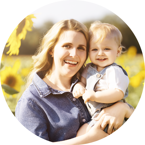 Mother cuddling her toddler in a sunflower field in Hampshire.