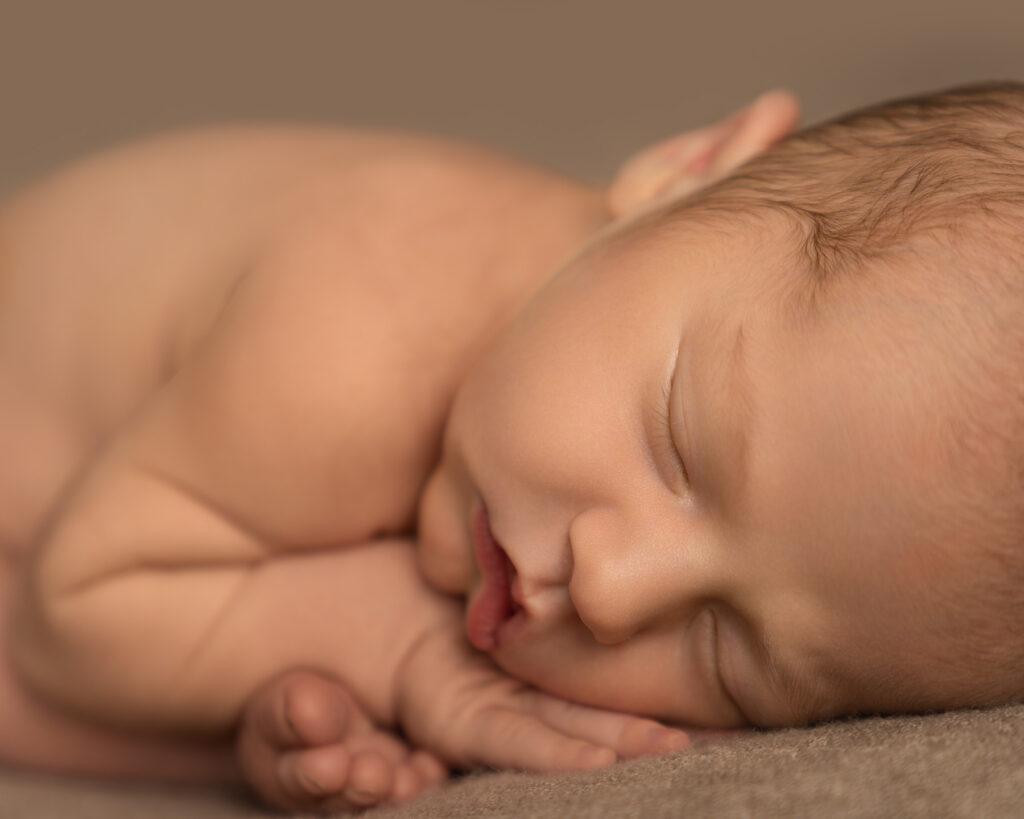 Peaceful sleeping newborn baby boy photographed by an Andover newborn photographer at a natural newborn photography session in Hampshire.