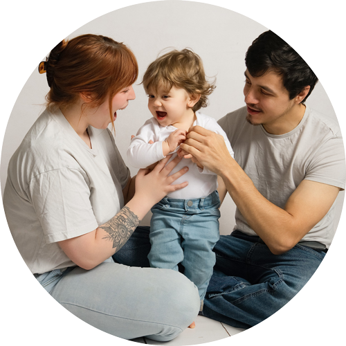 Natural family photography in Hampshire showing parents laughing and playing with their toddler in a relaxed studio photoshoot near Andover.