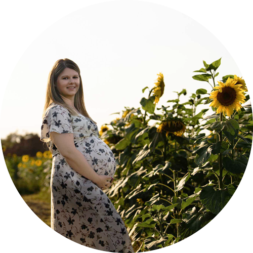 Mum-to-be during a sunflower maternity photoshoot in Hampshire, surrounded by golden sunflowers at sunset.