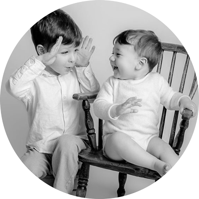 Two young siblings laughing together during a family portrait session near Andover, Hampshire
