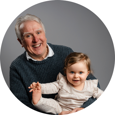 Grandfather smiling with his young granddaughter during a family photoshoot near Andover, Hampshire