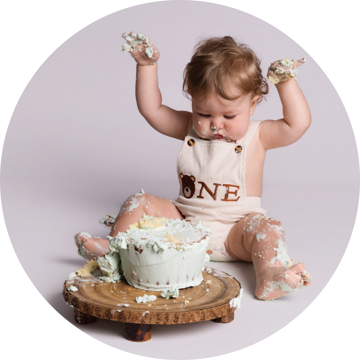 Baby celebrating their first birthday with a cake smash